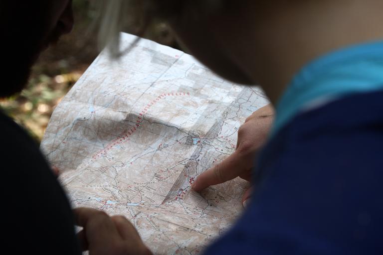 2 people looking at a map, one is pointing a the map